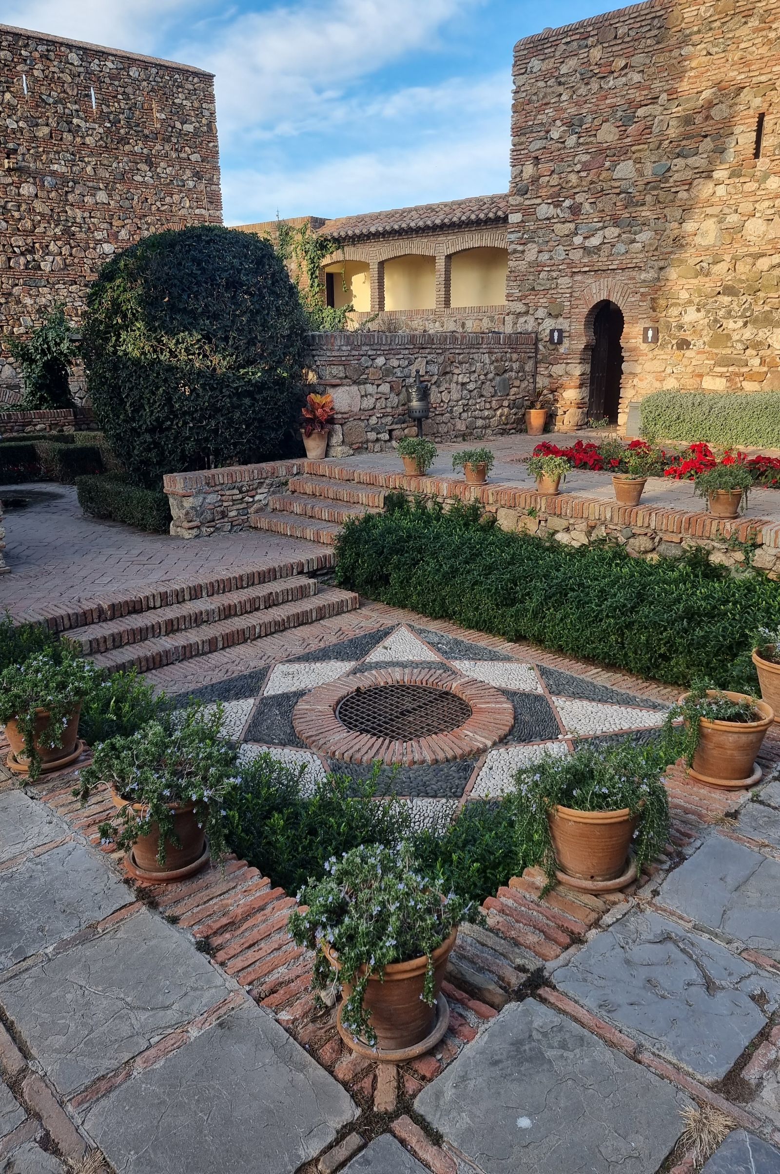 Stone and brick courtyard with a decorative pebble medallion inlay