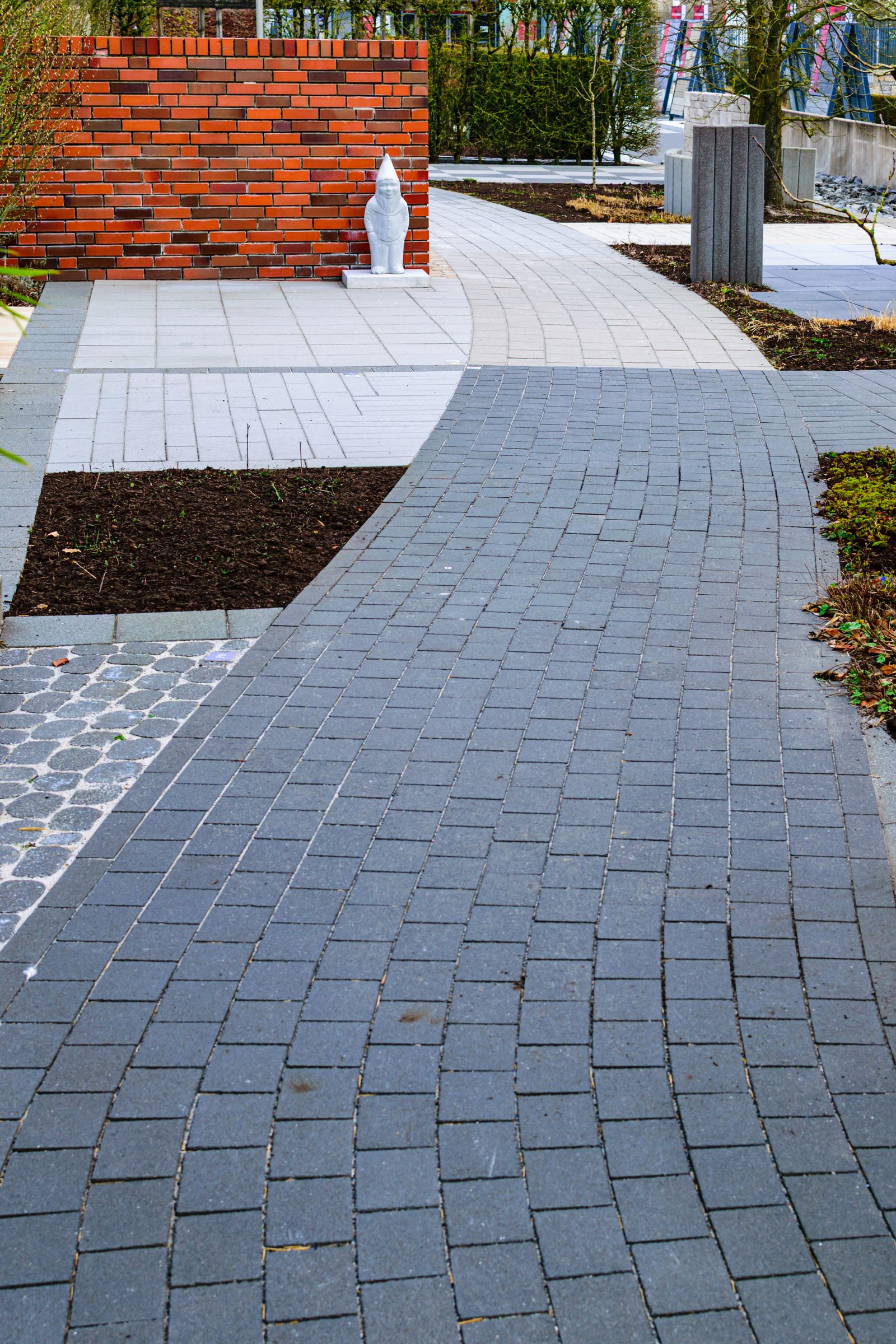 Curved paver walkway winding through a landscaped garden