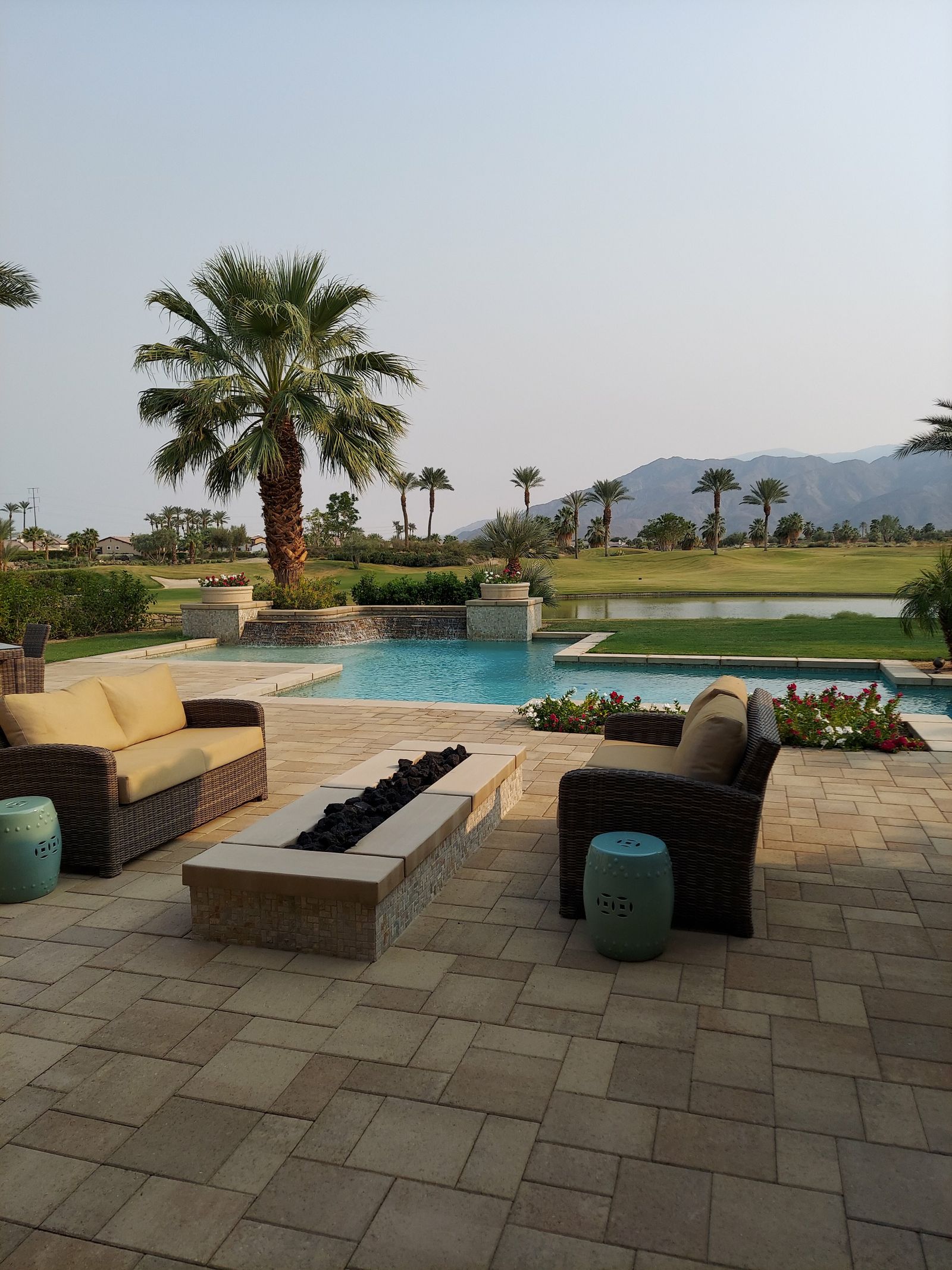 Paver pool deck patio with fire table and mountain view